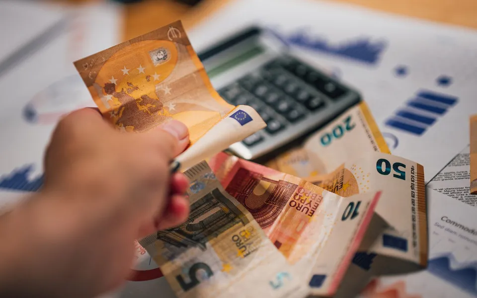 Billetes de euro, calculadora y documentos financieros sobre una mesa